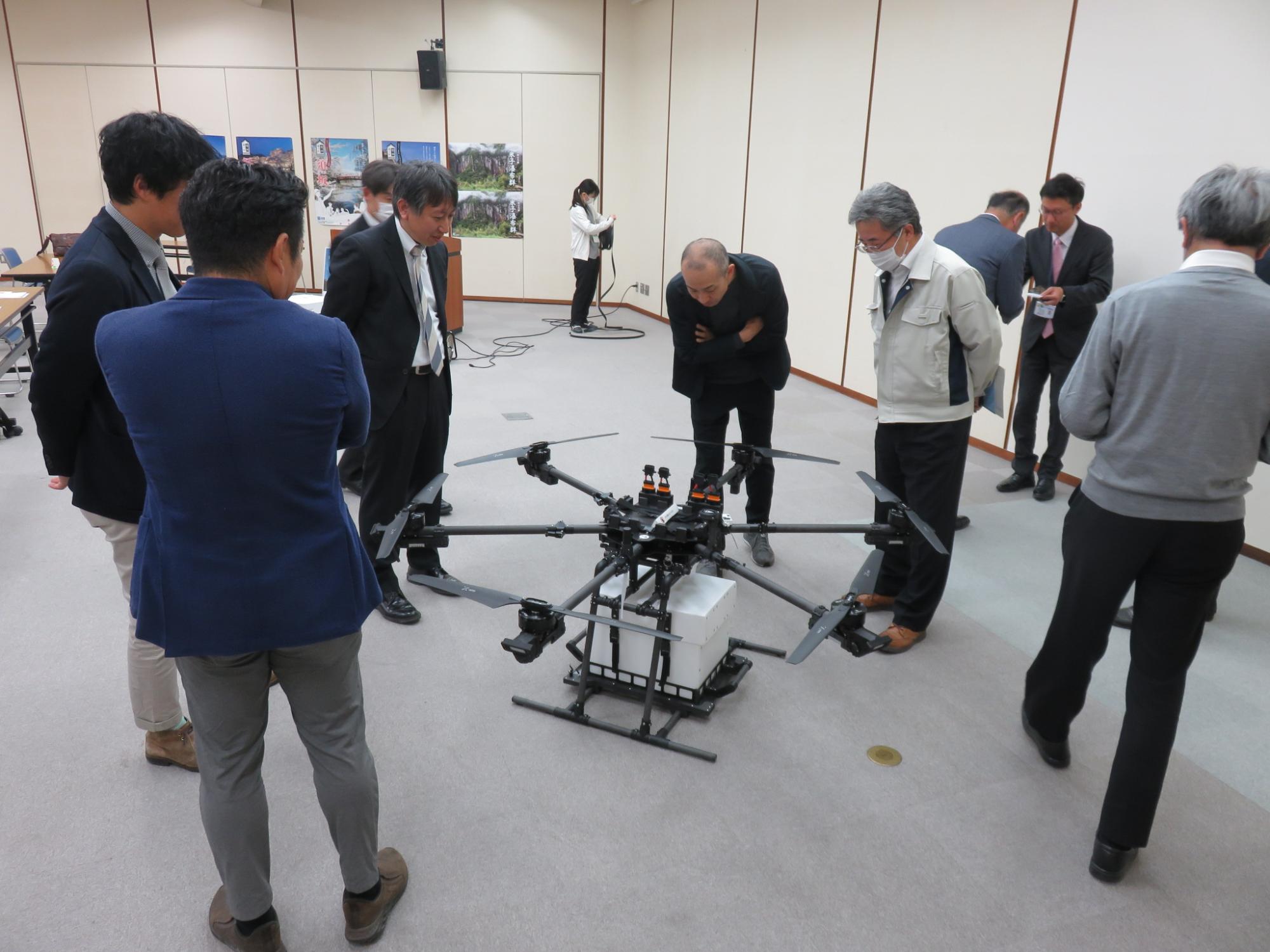 ドローンをのぞき込む講演会参加者の様子の写真