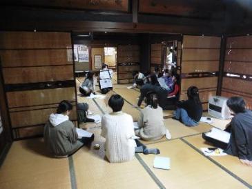 古民家の畳の部屋に座り説明を聞く様子写真
