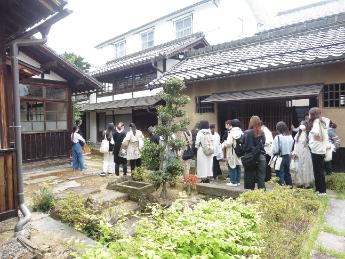 旧小田切家住宅の庭で説明を聞く清泉女学院大学の生徒たち