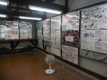 信州大学工学部3年生の作品を拡大印刷しパネルにしたものを壁にかけて展示している写真