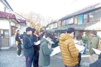 街区の再生の授業で、重伝建地区の建物を前に説明を聞く学生たちの写真