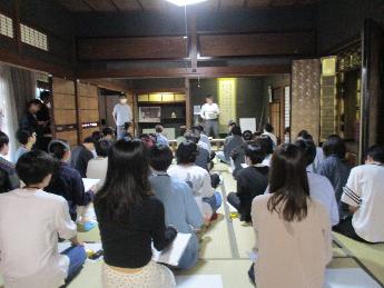 「民家の再生」「民家と工芸」授業で、旧越家住宅の和室で説明を聞く学生たちの写真
