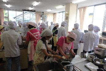 中央地域公民館でおやき作りの調理実習をする県立大学の生徒たちの写真