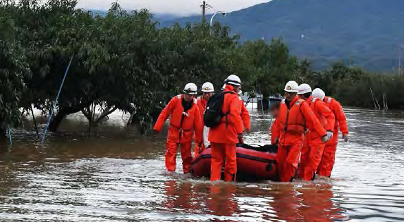 冠水した道路でボートを使いながら救助活動をしている隊員たちの様子を写した写真