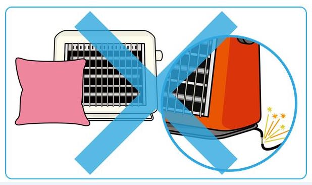電気ストーブの近くに燃えやすいクッションが置かれ、電気ストーブに破損がないことを確認する様子の写真