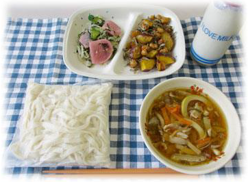 ソフト麺や汁物、サラダ、牛乳などの給食の写真