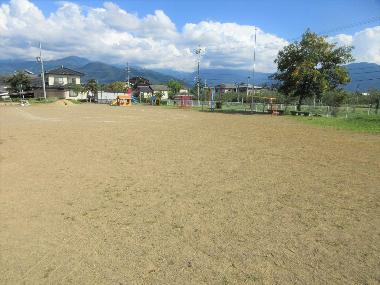 相之島保育園園舎から園庭を撮影。とても広い園庭。奥にあるジャングルジムや鉄棒などが小さく見える。
