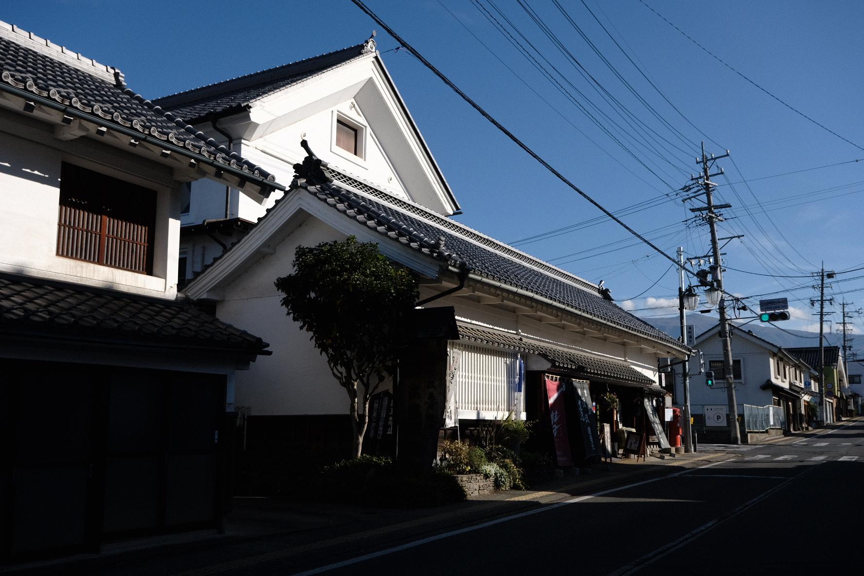 遠藤酒造場店舗正面、道路に面し点店舗があり、白壁に瓦屋根の重厚なつくり。店舗入り口には日光を遮断する暗い色のガラス引き戸。商品名「渓流」と書かれた暖簾幕が立てかけられている。