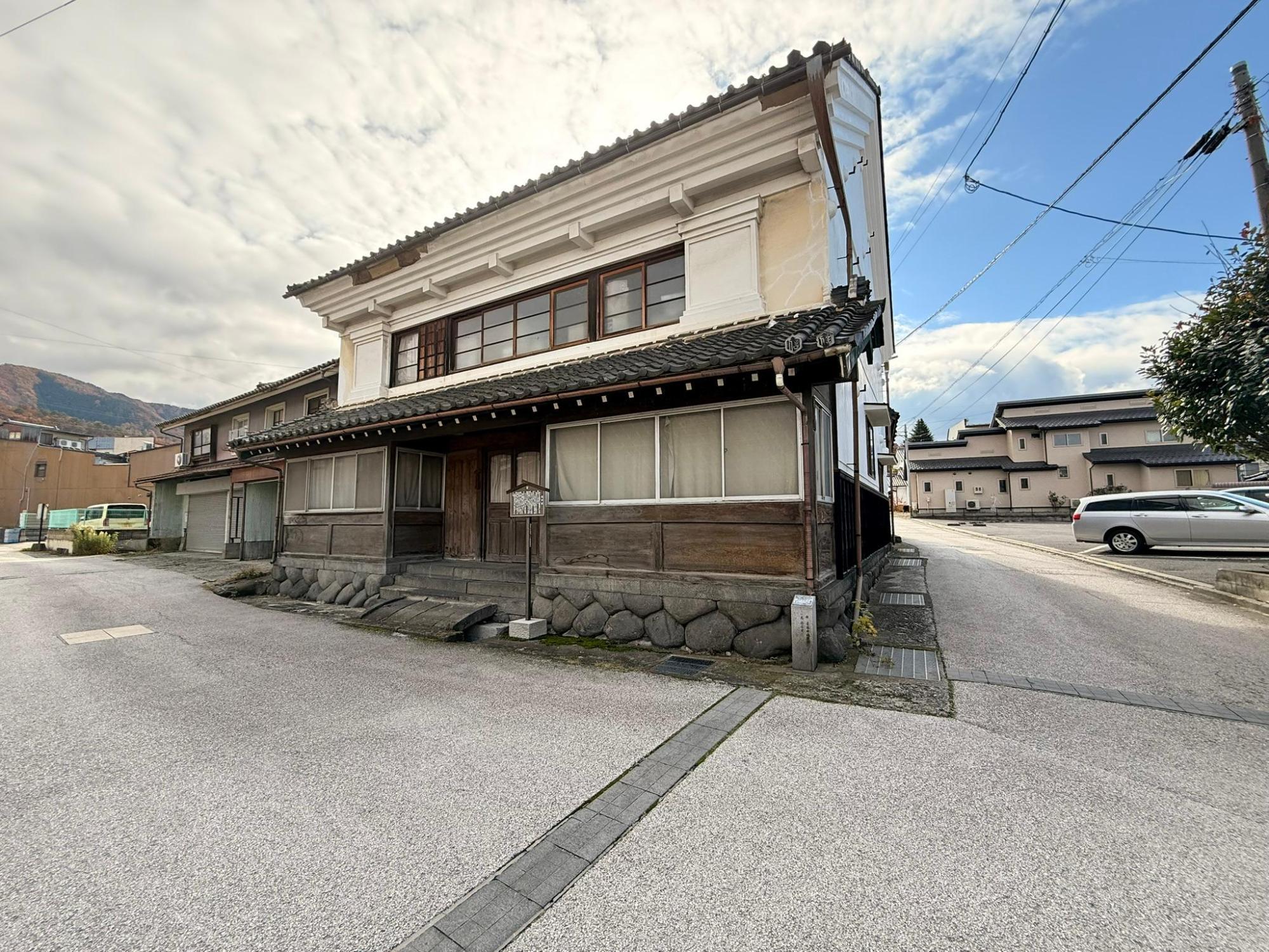 旧信用銀行の建物。ぼたもち石積みの上に木造の入り口。建物全体は白壁で瓦屋根が乗っている蔵づくり。そんなに大きくはない。