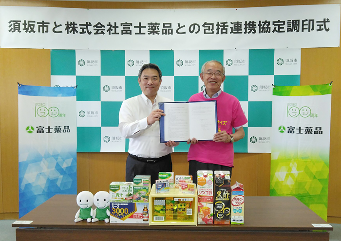 調印した協定書を手にとり並ぶ富士薬品代表者と三木市長の写真