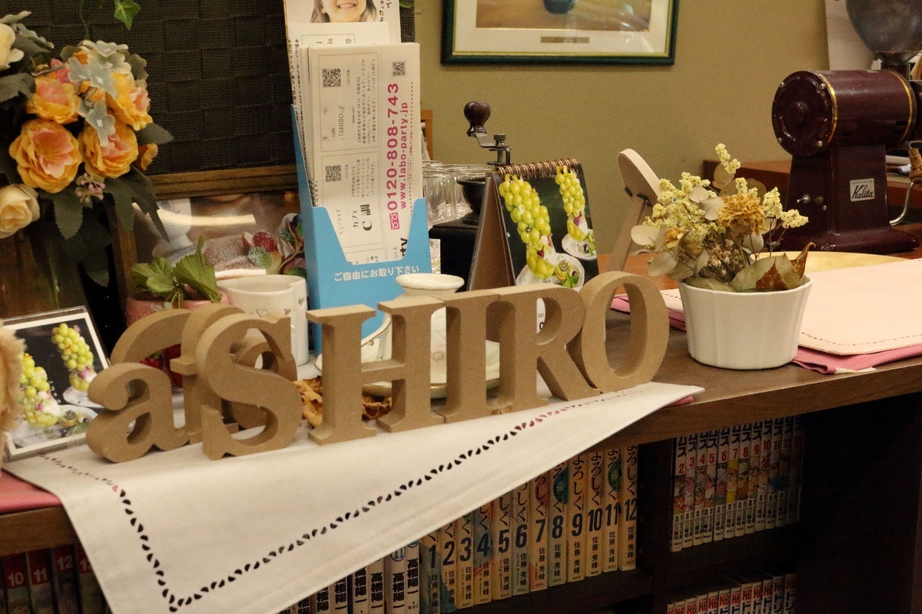 本棚の上に置かれたCAFE SHIRO木製アルファベットオブジェの写真